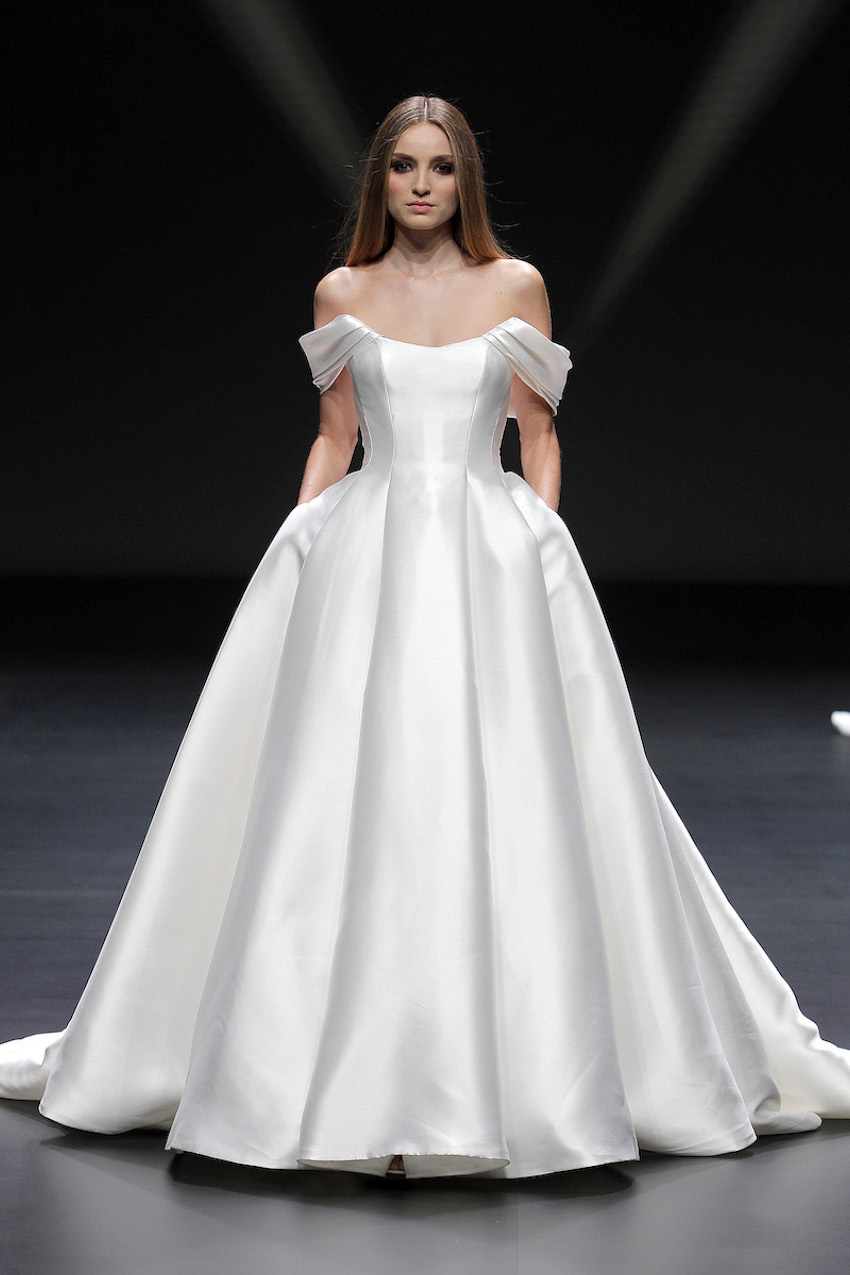 A Pronovias bridal model wearing a tight wasted and ballgown style dress