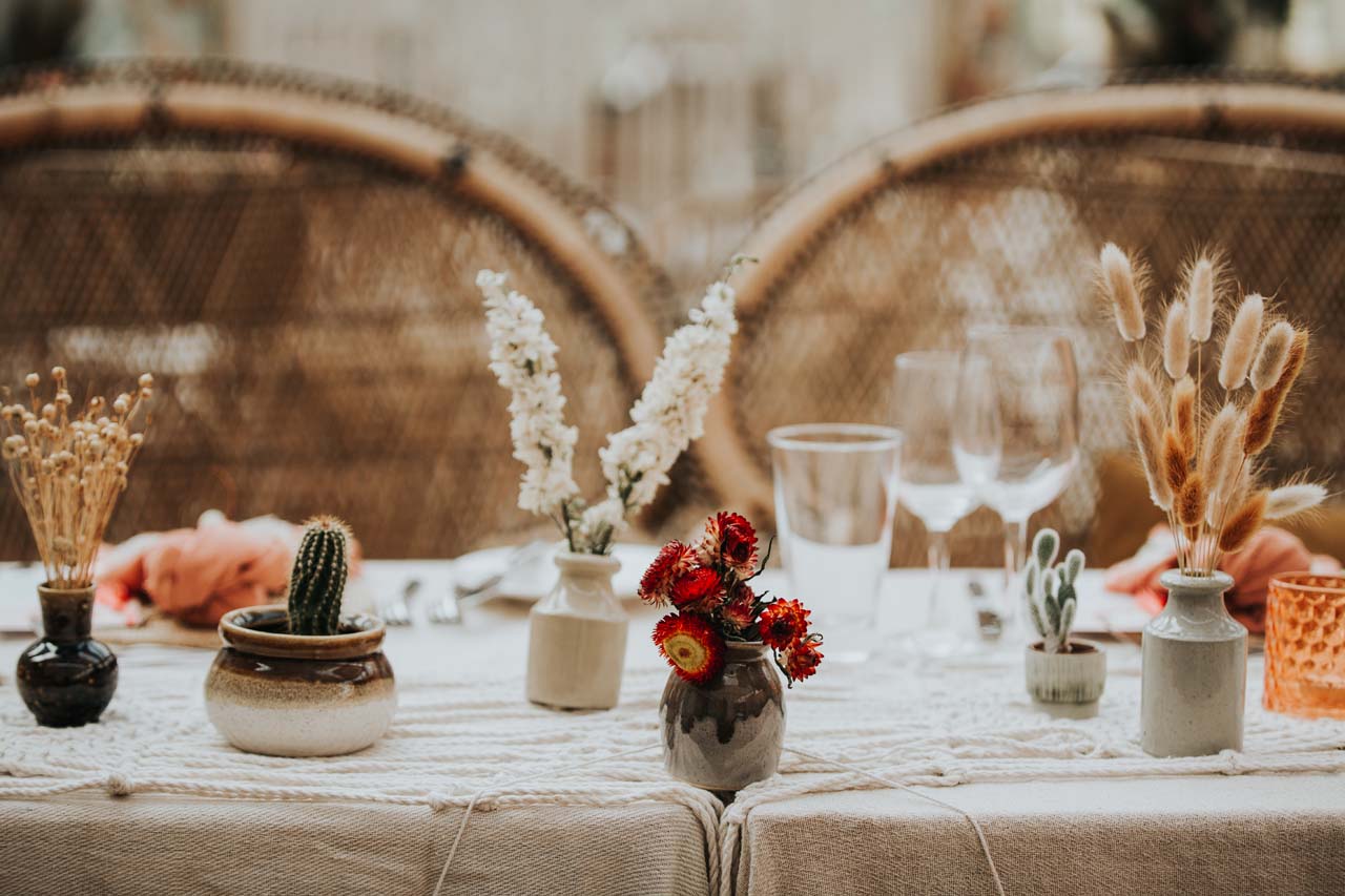 A table with potted plants and dried flowers